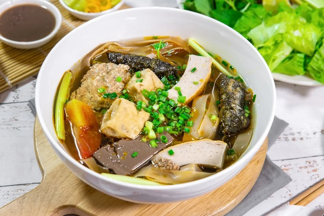 Bánh đa cua cô bông với tô bánh nóng và nước dùng thanh