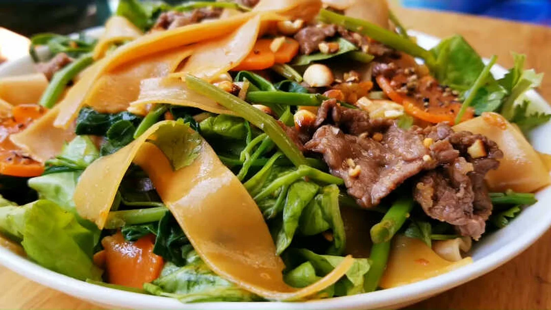 Bánh đa xào thịt bò rau muống với sợi bánh mềm dai bánh đa trộn thịt bò rau muống với sợi bánh mềm dai
